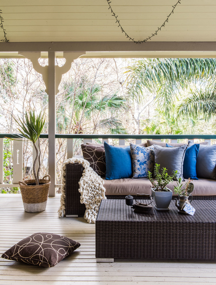 Mid-sized tropical backyard deck in Brisbane with a roof extension.