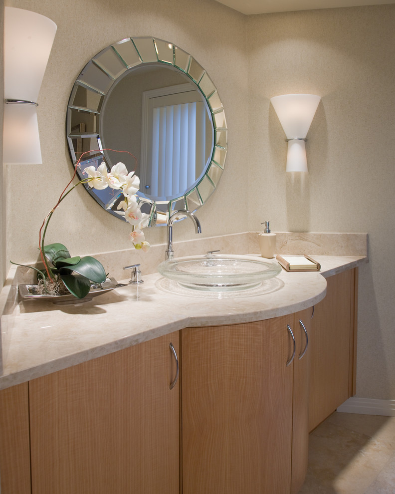 This is an example of a mid-sized contemporary master bathroom in San Diego with a vessel sink, flat-panel cabinets, medium wood cabinets, beige tile, stone slab, beige walls, limestone floors and limestone benchtops.