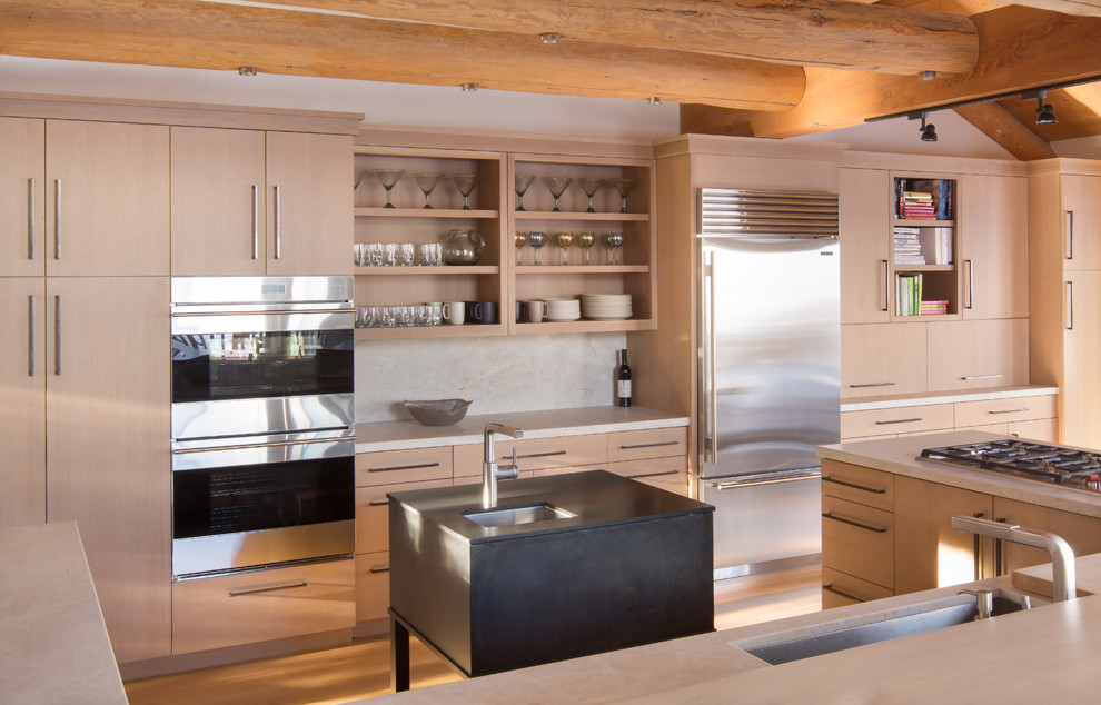 Photo of a country u-shaped kitchen in Other with an undermount sink, flat-panel cabinets, light wood cabinets, white splashback, stainless steel appliances, medium hardwood floors and with island.