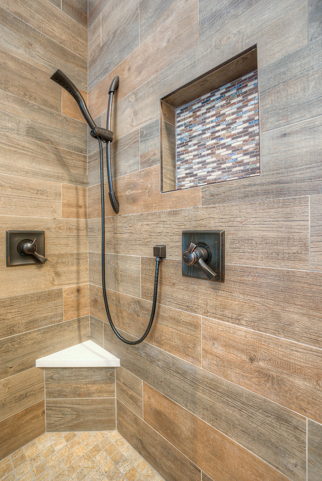 This is an example of a mid-sized modern master bathroom in Phoenix with recessed-panel cabinets, dark wood cabinets, a freestanding tub, a curbless shower, a two-piece toilet, beige tile, blue tile, brown tile, multi-coloured tile, matchstick tile, beige walls, porcelain floors, an undermount sink and solid surface benchtops.
