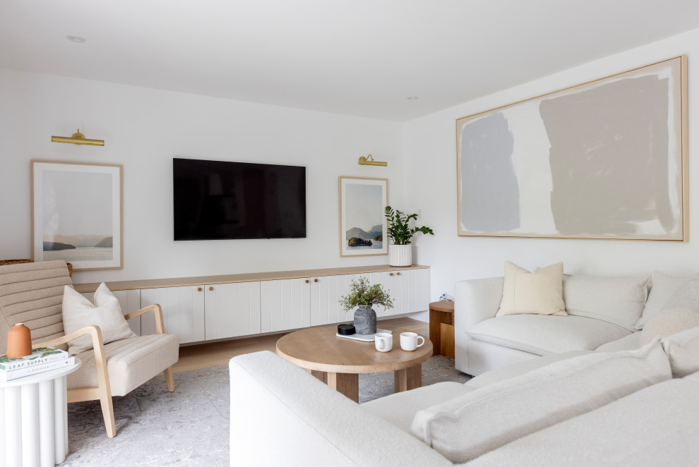 Источник вдохновения для домашнего уюта: открытая гостиная комната среднего размера в скандинавском стиле с светлым паркетным полом, телевизором на стене, коричневым полом и белыми стенами без камина