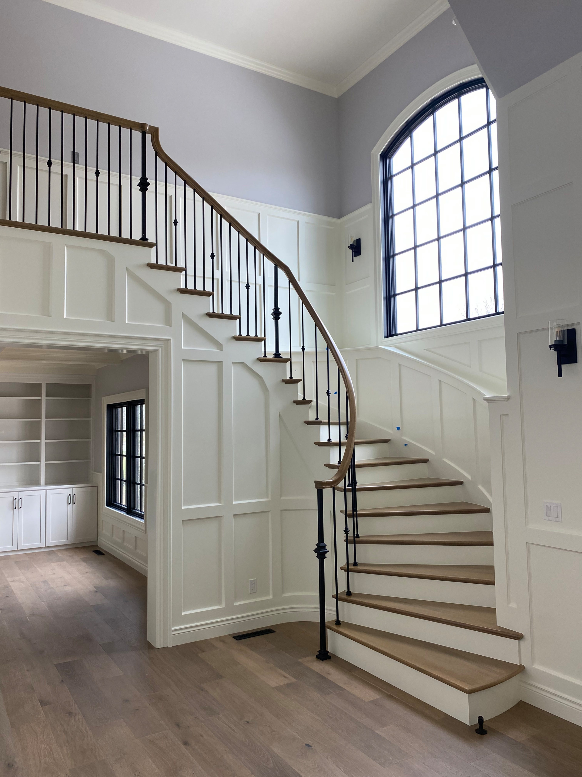 Painted and stained entry staircase with white painted wainscoting