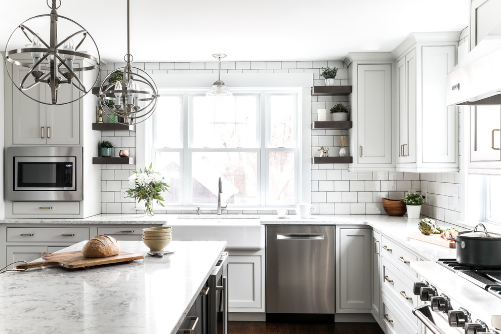Transitional l-shaped medium tone wood floor and brown floor eat-in kitchen photo in Boston with a farmhouse sink, beaded inset cabinets, white cabinets, quartz countertops, white backsplash, subway tile backsplash, stainless steel appliances, an island and gray countertops