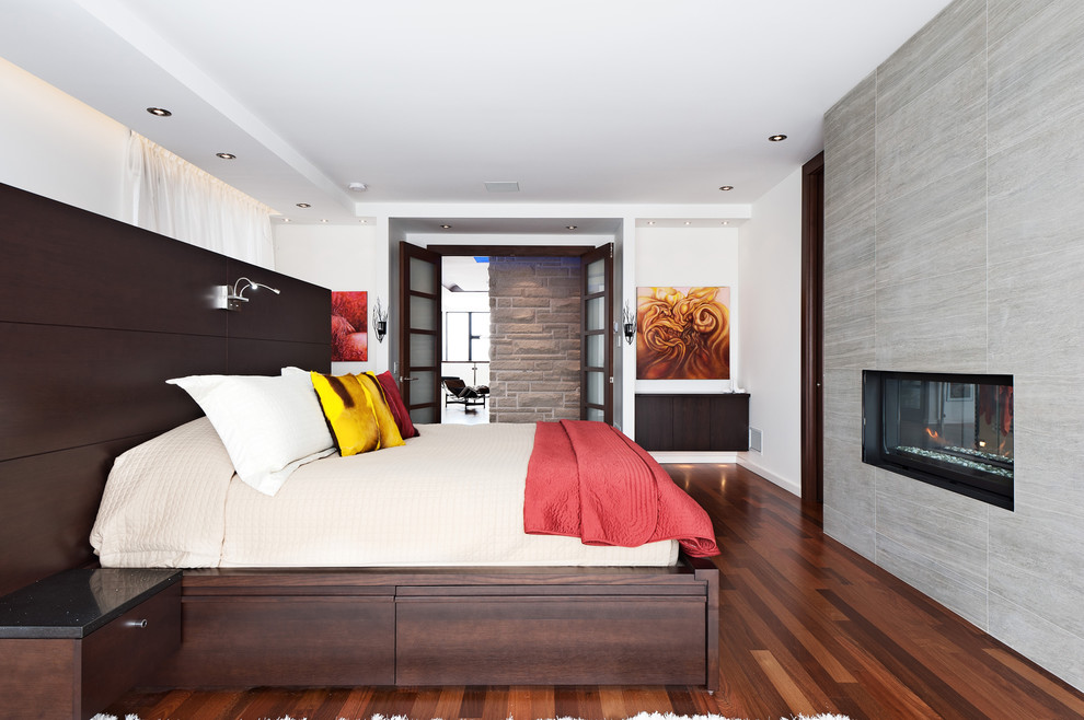 This is an example of a contemporary bedroom in Montreal with a ribbon fireplace.