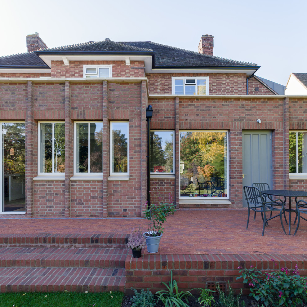 Medium sized contemporary back patio in London with brick paving and no cover.