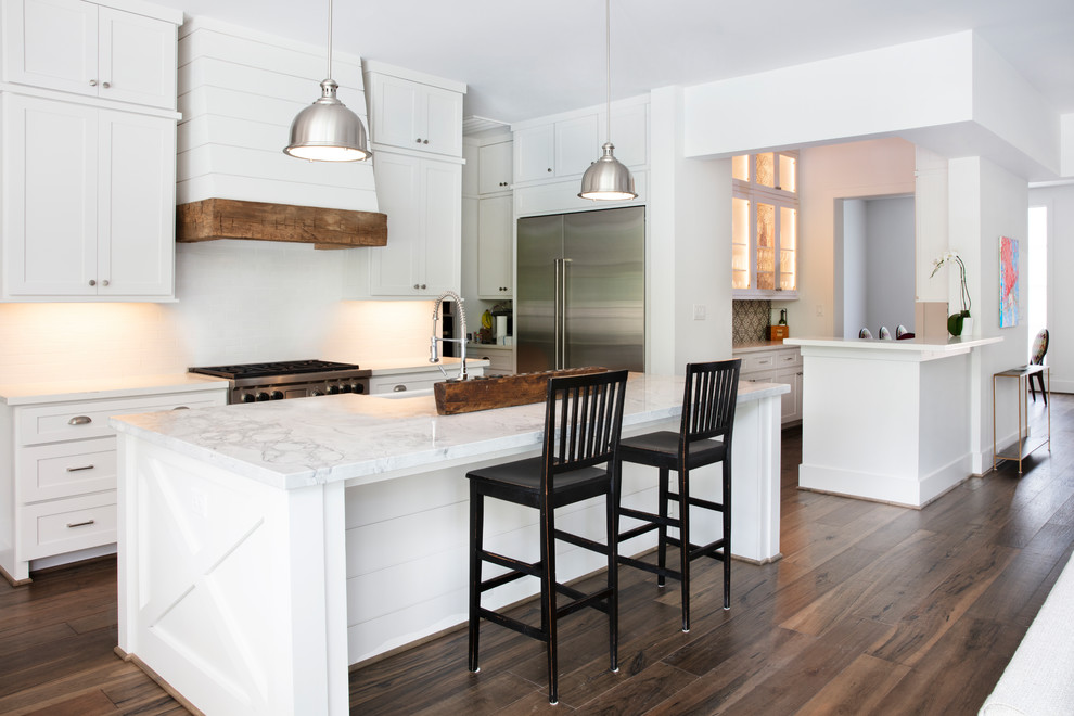 Kitchen - country galley dark wood floor and brown floor kitchen idea in Houston with a farmhouse sink, shaker cabinets, white cabinets, stainless steel appliances, an island and white countertops