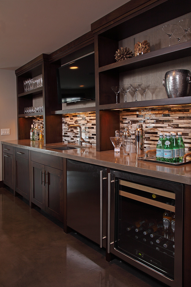 Mid-sized transitional galley seated home bar in Minneapolis with an undermount sink, open cabinets, dark wood cabinets, wood benchtops, multi-coloured splashback, matchstick tile splashback, concrete floors and grey floor.