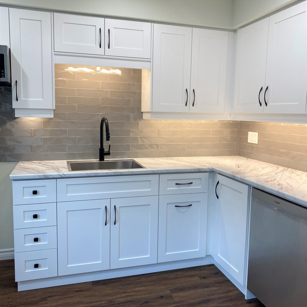 Eat-in kitchen - mid-sized transitional galley vinyl floor eat-in kitchen idea in Toronto with a drop-in sink, shaker cabinets, white cabinets, laminate countertops, gray backsplash and stainless steel appliances