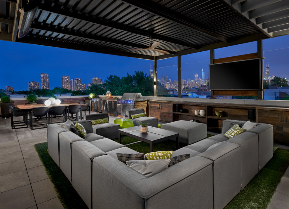 Expansive contemporary rooftop deck in Chicago with an outdoor kitchen and an awning.