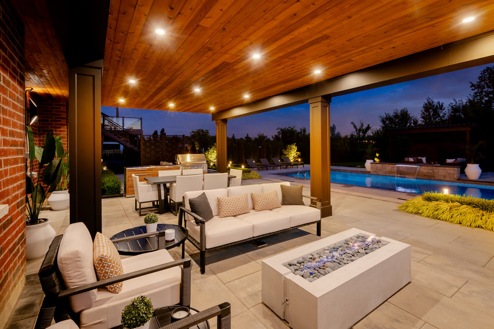 Inspiration for a large transitional backyard concrete paver and rectangular lap pool landscaping remodel in Toronto