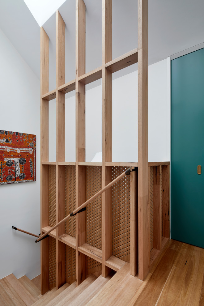 Cette image montre un grand escalier design en U et bois avec des marches en bois, des contremarches en bois et un garde-corps en bois.