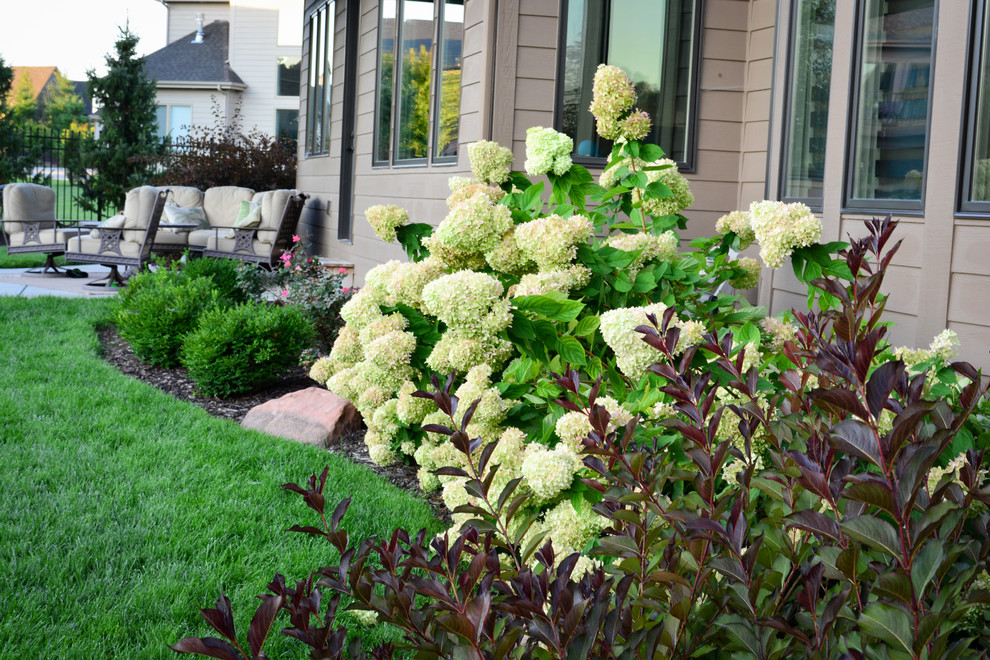 Inspiration for a mid-sized rustic partial sun backyard mulch landscaping in Omaha.