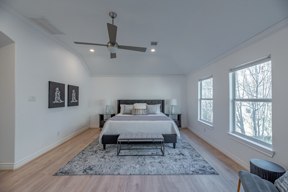 Photo of a mid-sized transitional master bedroom in Houston with white walls and laminate floors.