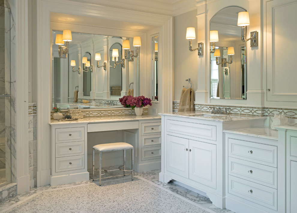 Design ideas for an expansive traditional master bathroom in Boston with recessed-panel cabinets, white cabinets, a freestanding tub, a corner shower, beige tile, glass tile, white walls, ceramic floors, a drop-in sink and marble benchtops.
