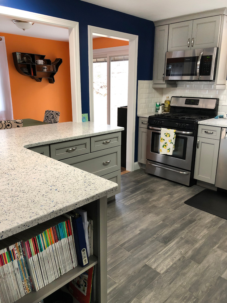 Mid-sized modern l-shaped eat-in kitchen in Boston with an undermount sink, shaker cabinets, grey cabinets, recycled glass benchtops, white splashback, ceramic splashback, stainless steel appliances, porcelain floors, grey floor and white benchtop.