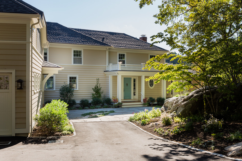 This is an example of a mid-sized traditional wood beige front porch design in Boston with decking and a roof extension.
