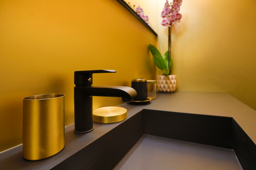 This is an example of a small transitional 3/4 bathroom in Nice with glass-front cabinets, a curbless shower, yellow tile, metal tile, yellow walls, ceramic floors, an integrated sink, granite benchtops, black floor, an open shower and black benchtops.
