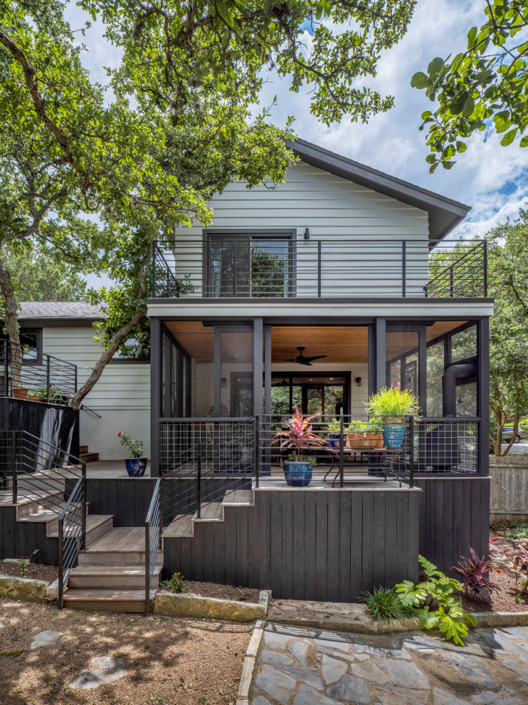 Inspiration for a medium sized modern back screened metal railing veranda in Austin with a roof extension.