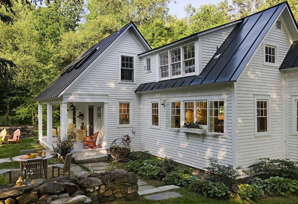 Inspiration for a small country two-storey exterior in Burlington with wood siding and a metal roof.