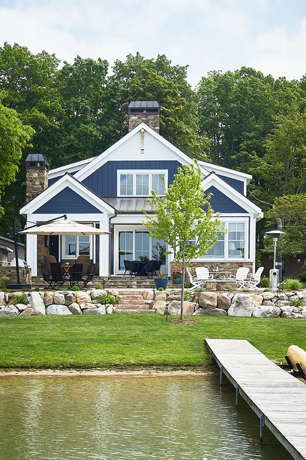 Photo of a mid-sized beach style two-storey blue house exterior in Grand Rapids with concrete fiberboard siding, a gable roof and a mixed roof.