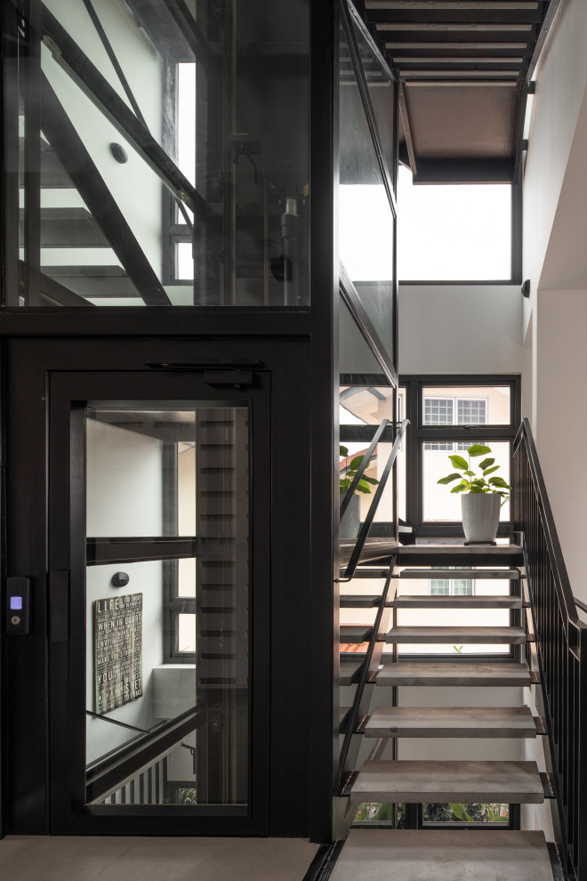 Стильный дизайн: п-образная лестница в современном стиле с бетонными ступенями и металлическими перилами без подступенок - последний тренд