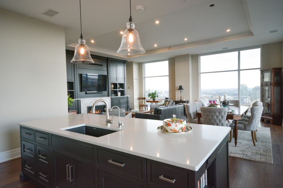 Open concept kitchen - transitional single-wall medium tone wood floor and brown floor open concept kitchen idea in Toronto with an undermount sink, shaker cabinets, white cabinets, quartz countertops, white backsplash, marble backsplash, paneled appliances, an island and white countertops
