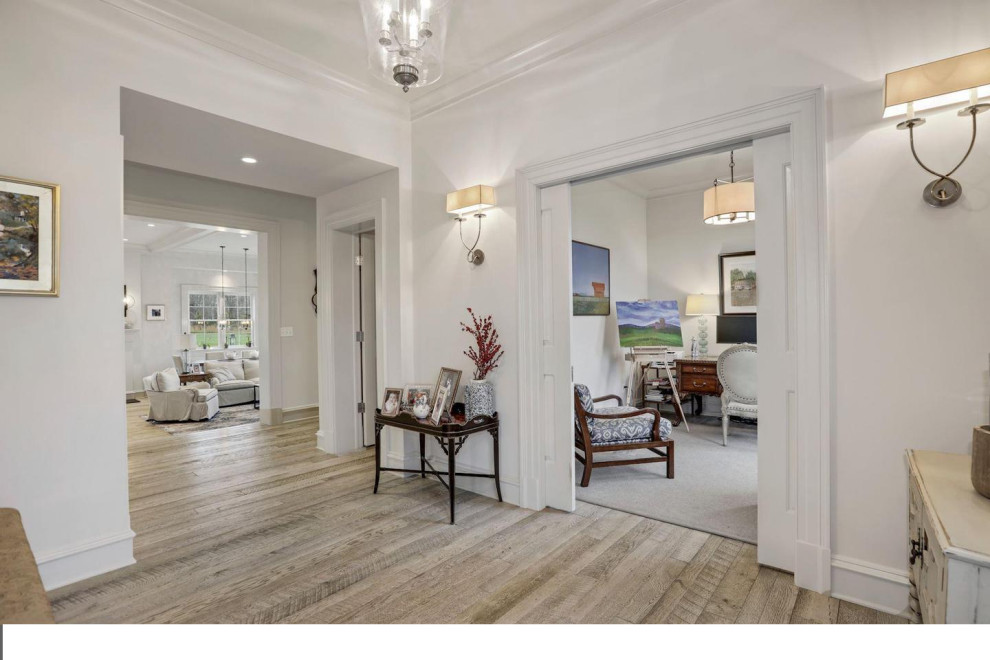 Example of a mid-sized transitional light wood floor foyer design in DC Metro with gray walls and a black front door