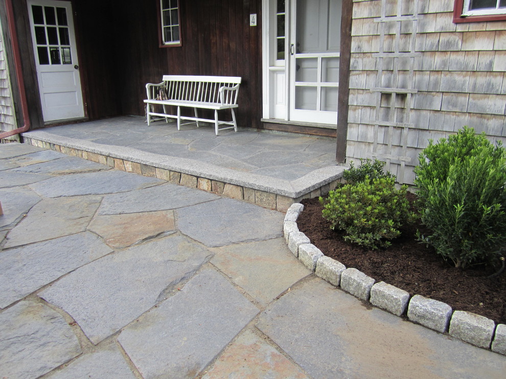 Photo of a mid-sized traditional front yard patio in Boston with natural stone pavers and no cover.
