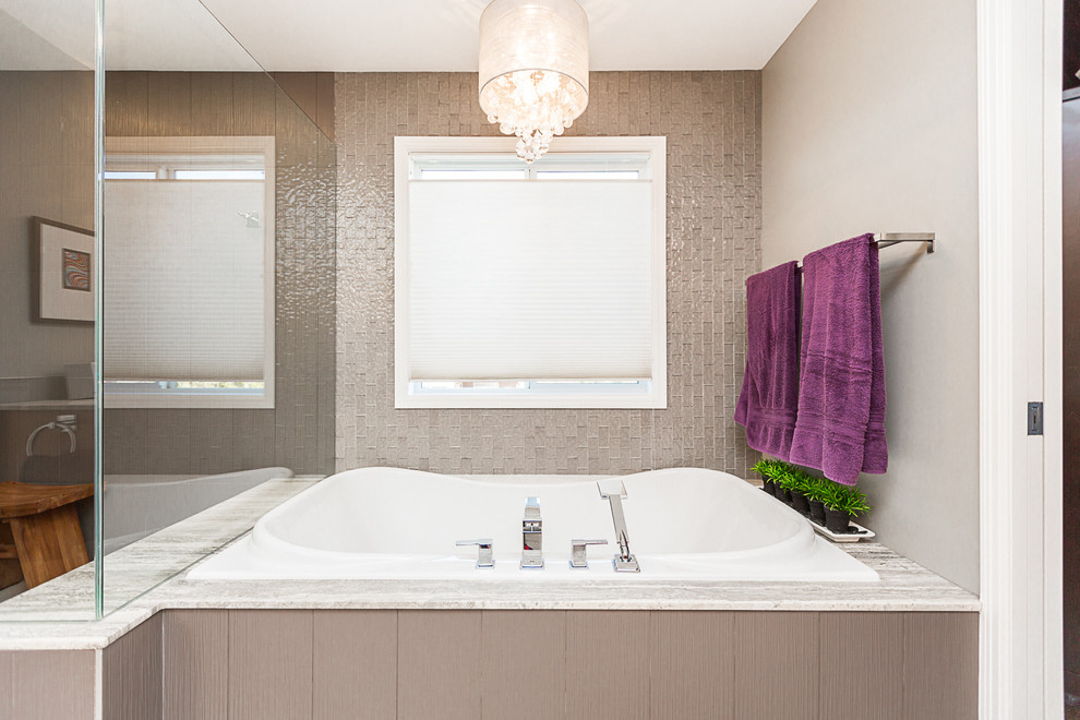 Design ideas for a large transitional master bathroom in Calgary with a drop-in tub, shaker cabinets, light wood cabinets, a corner shower, gray tile, glass tile, beige walls, ceramic floors, an undermount sink and granite benchtops.