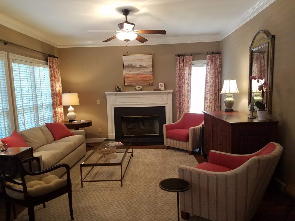 Photo of a mid-sized traditional enclosed family room in Other with beige walls, dark hardwood floors, a standard fireplace, a stone fireplace surround, no tv and brown floor.