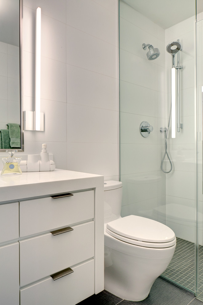 Inspiration for a small contemporary kids bathroom in New York with flat-panel cabinets, white cabinets, an alcove tub, a shower/bathtub combo, a two-piece toilet, white tile, subway tile, white walls, ceramic floors, an integrated sink, solid surface benchtops, orange floor and an open shower.