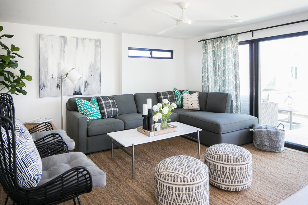 This is an example of a beach style living room in San Diego with white walls.