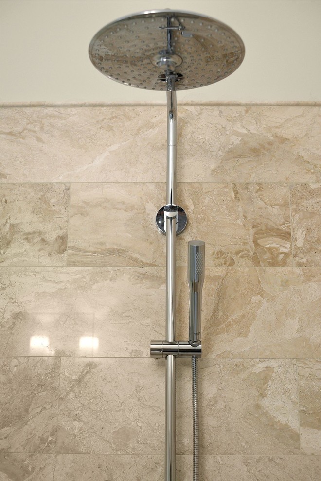 Example of a mid-sized transitional 3/4 beige tile and marble tile marble floor and beige floor alcove shower design in Jacksonville with a two-piece toilet, beige walls, a console sink and a hinged shower door