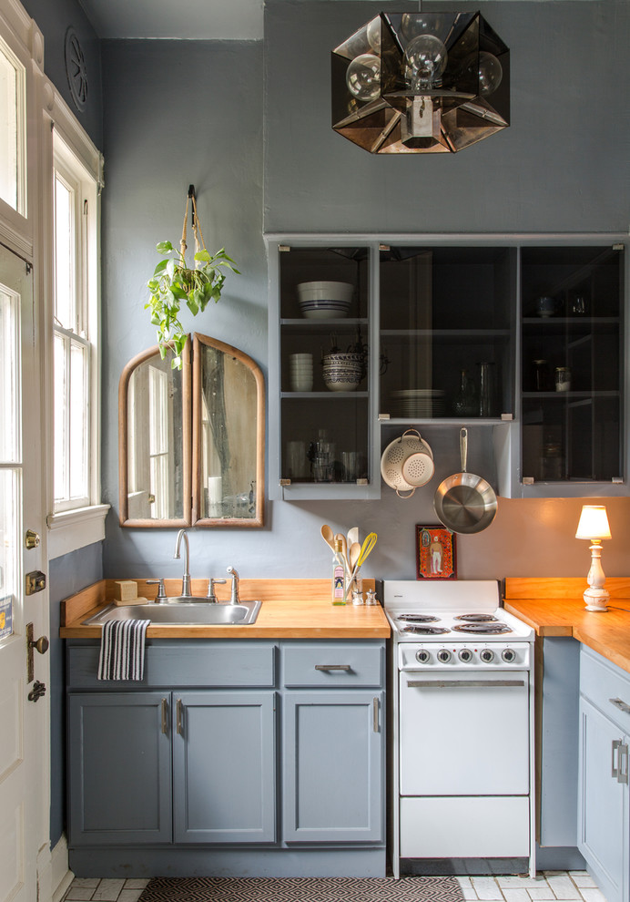 Design ideas for a small traditional l-shaped kitchen in New Orleans with a drop-in sink, shaker cabinets, grey cabinets, wood benchtops, white appliances and a peninsula.