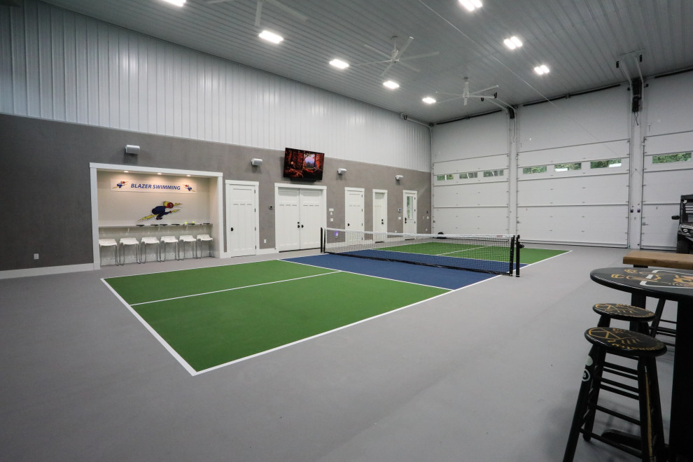 Immagine di un ampio campo sportivo coperto country con pareti grigie e pavimento grigio