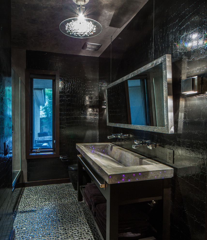 This is an example of a contemporary bathroom in Orlando with a trough sink, concrete benchtops, black tile, open cabinets, black cabinets, a one-piece toilet and black walls.