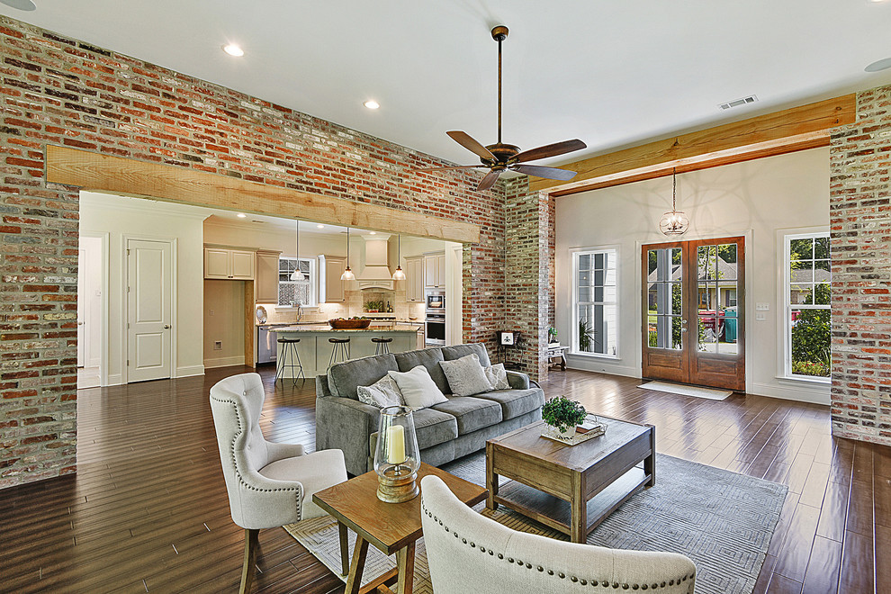 This is an example of a large transitional open concept living room in New Orleans with brown walls, medium hardwood floors and brown floor.