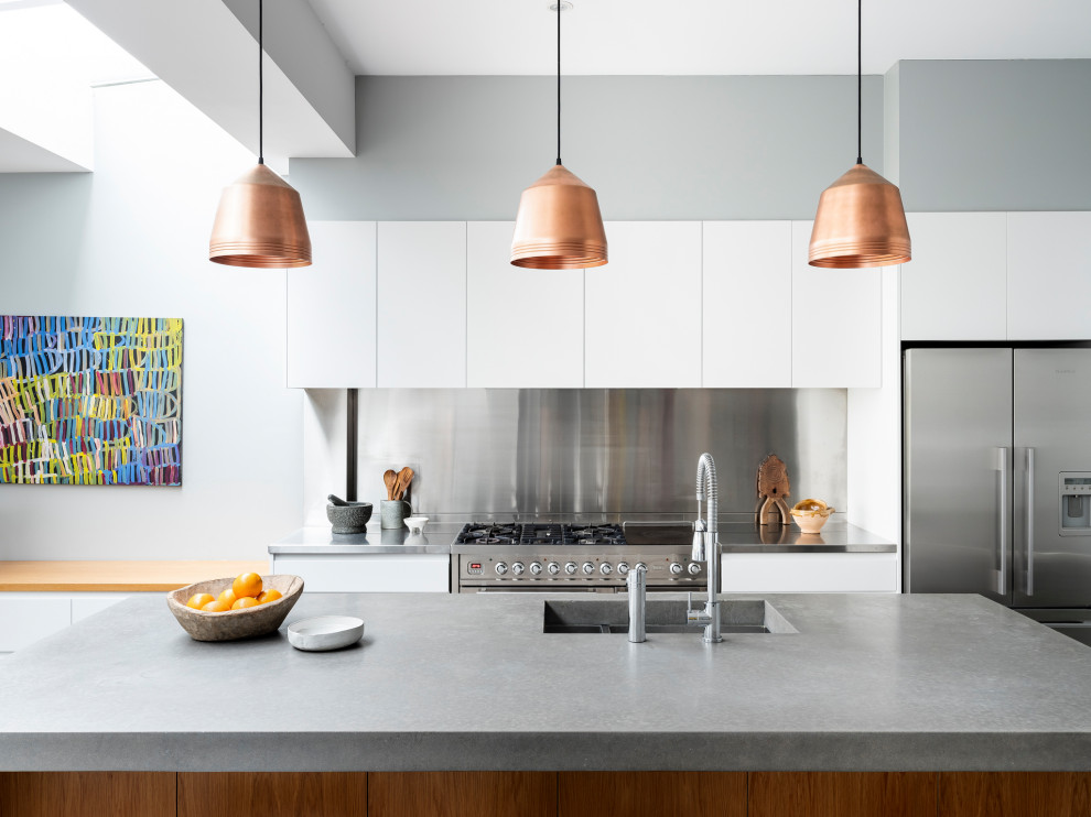 Idee per un grande cucina con isola centrale design con top in cemento, parquet scuro, pavimento marrone e top grigio