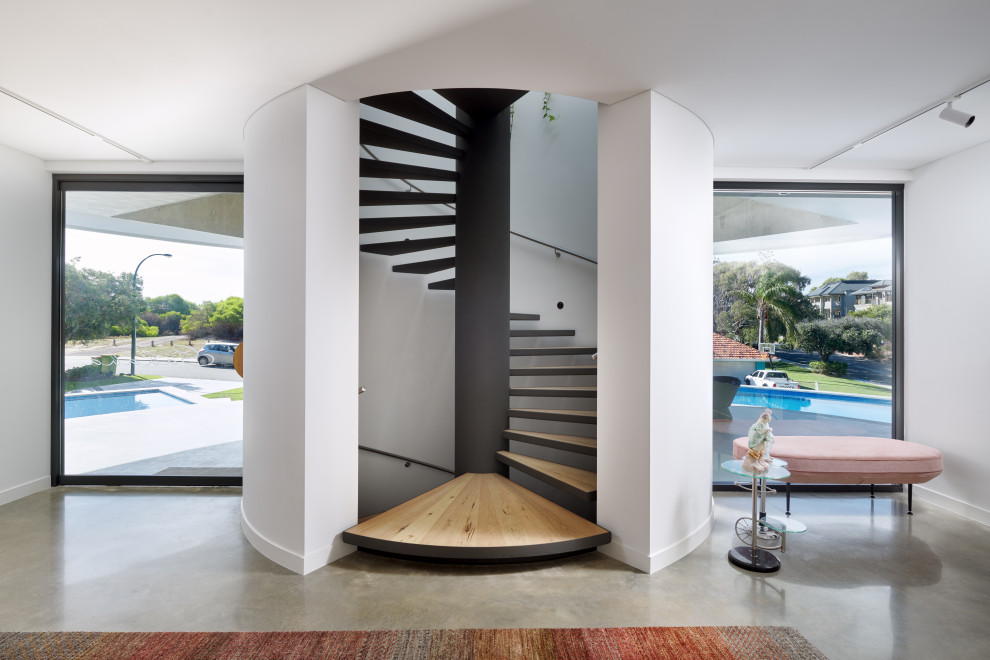 Expansive contemporary wood spiral staircase in Perth with open risers and metal railing.