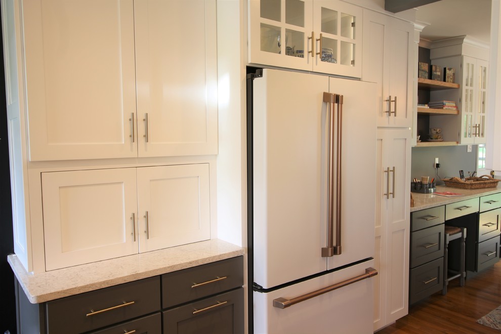 Inspiration for a mid-sized transitional u-shaped medium tone wood floor and brown floor enclosed kitchen remodel with a farmhouse sink, shaker cabinets, white cabinets, quartz countertops, white backsplash, subway tile backsplash, white appliances, no island and beige countertops