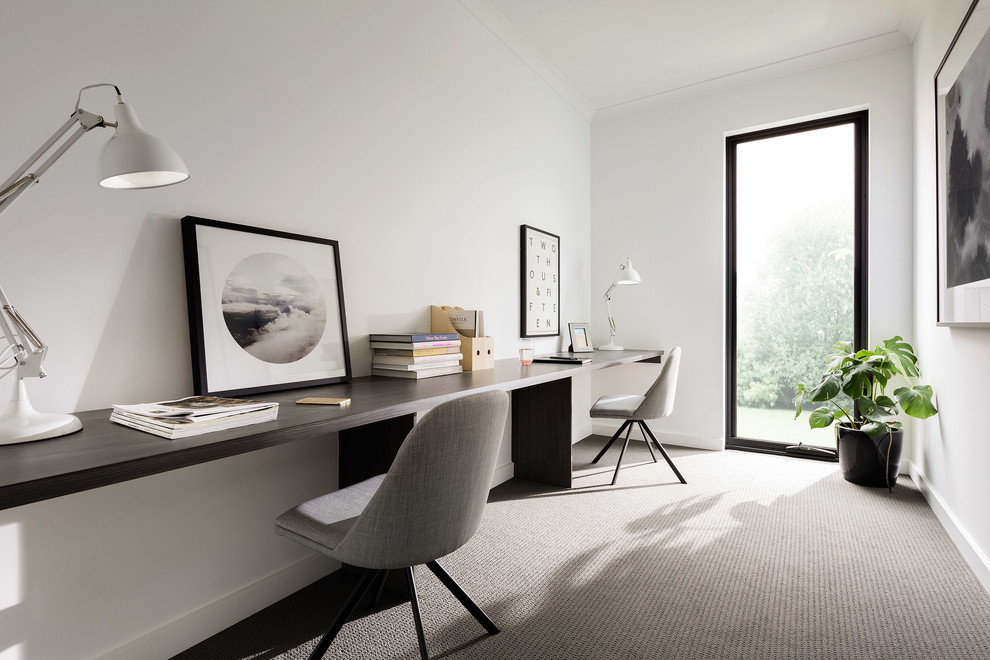 Large contemporary home office in Melbourne with white walls, carpet, a freestanding desk and grey floor.