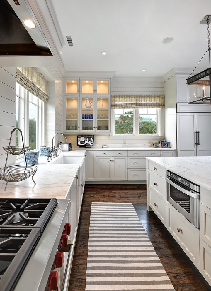 Large beach style u-shaped eat-in kitchen in Charleston with recessed-panel cabinets, stainless steel appliances, with island and a farmhouse sink.