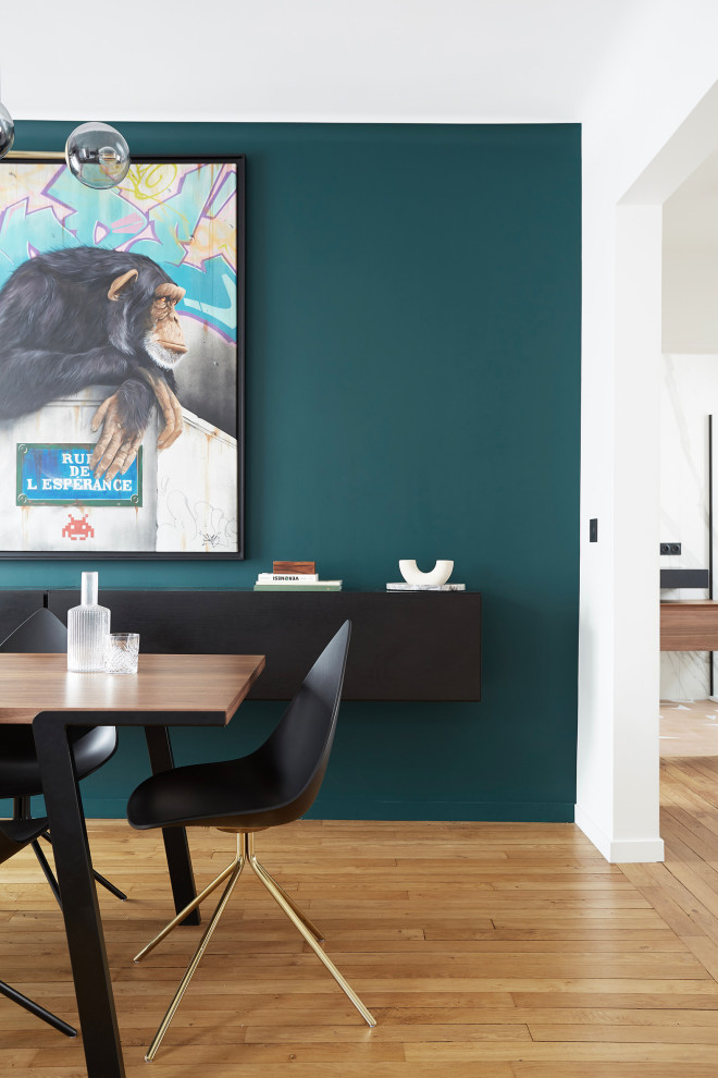 На фото: гостиная-столовая среднего размера в современном стиле с зелеными стенами, паркетным полом среднего тона и коричневым полом без камина с