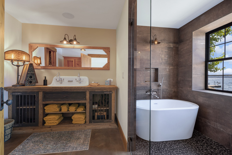 Mid-sized mountain style master brown tile and porcelain tile concrete floor, gray floor and single-sink freestanding bathtub photo in Seattle with shaker cabinets, medium tone wood cabinets, a two-piece toilet, white walls, a drop-in sink, wood countertops, brown countertops, a niche and a built-in vanity