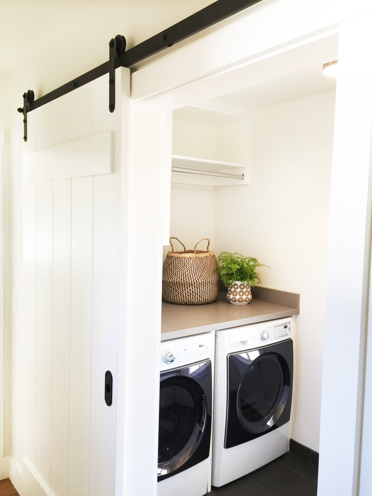 Design ideas for a mid-sized country dedicated laundry room in Santa Barbara with shaker cabinets, white cabinets, quartz benchtops, white walls, porcelain floors and a side-by-side washer and dryer.