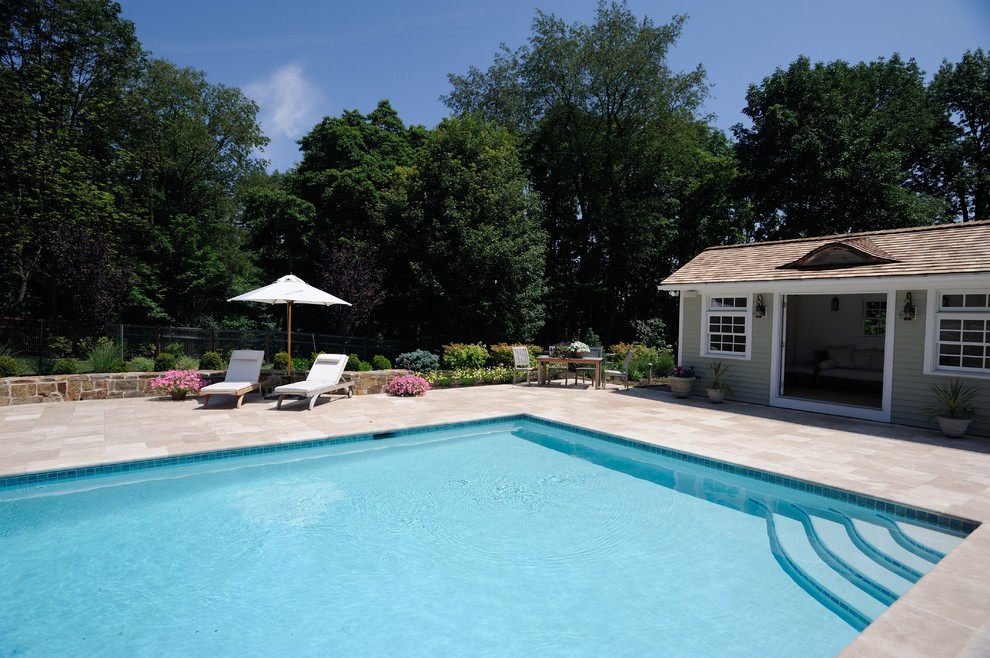 Large traditional backyard rectangular pool in New York with a pool house.