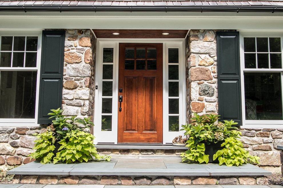 This is an example of a large arts and crafts front door in Philadelphia with a single front door and a medium wood front door.