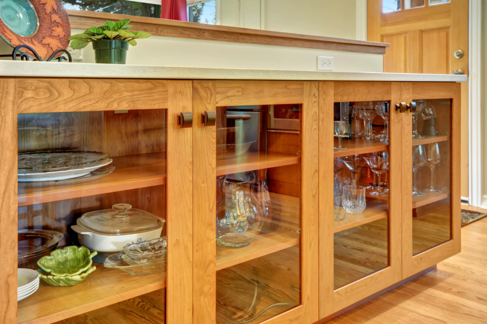 Eat-in kitchen - l-shaped medium tone wood floor and brown floor eat-in kitchen idea in Seattle with an undermount sink, shaker cabinets, medium tone wood cabinets, red backsplash, mosaic tile backsplash, stainless steel appliances, an island and white countertops