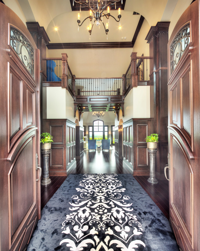 Photo of an expansive traditional entry hall in Other with beige walls, dark hardwood floors, a double front door and a dark wood front door.