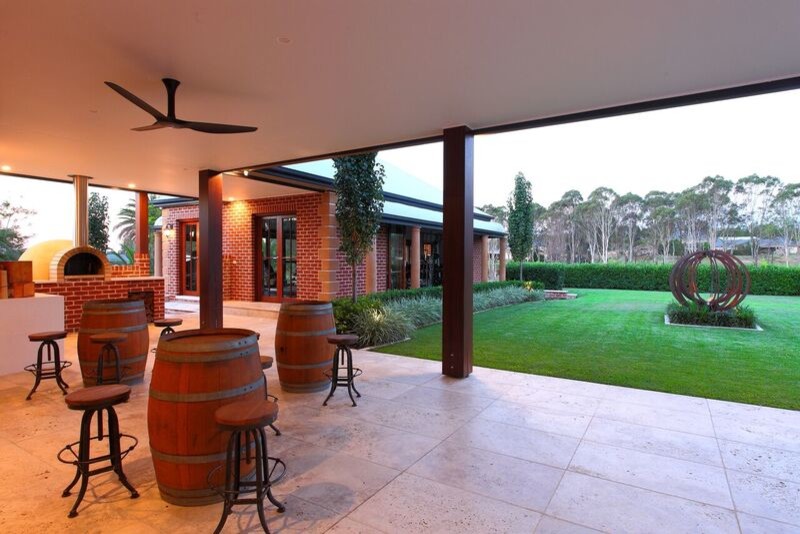 This is an example of a large contemporary backyard patio in Sydney with an outdoor kitchen and a roof extension.